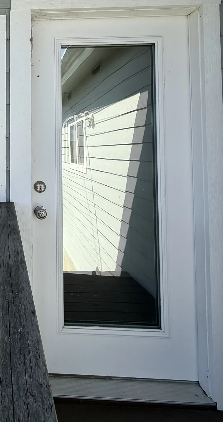 Exterior of a sunroom entry door with R Silver 20i film, reflecting the siding