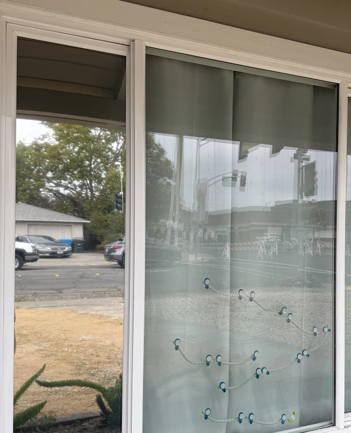 Street-facing front window before film: curtains drawn against the road