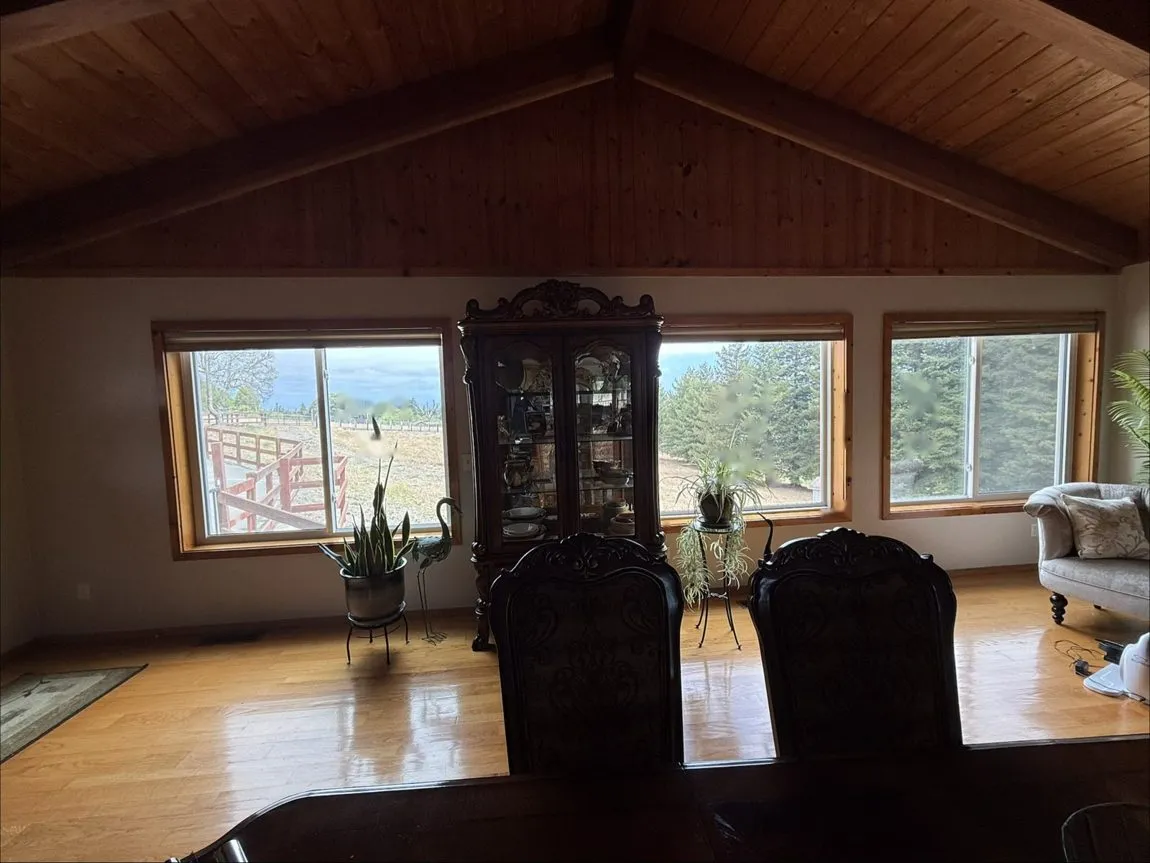 Vaulted great room before window film: glare across the floor and a washed-out view
